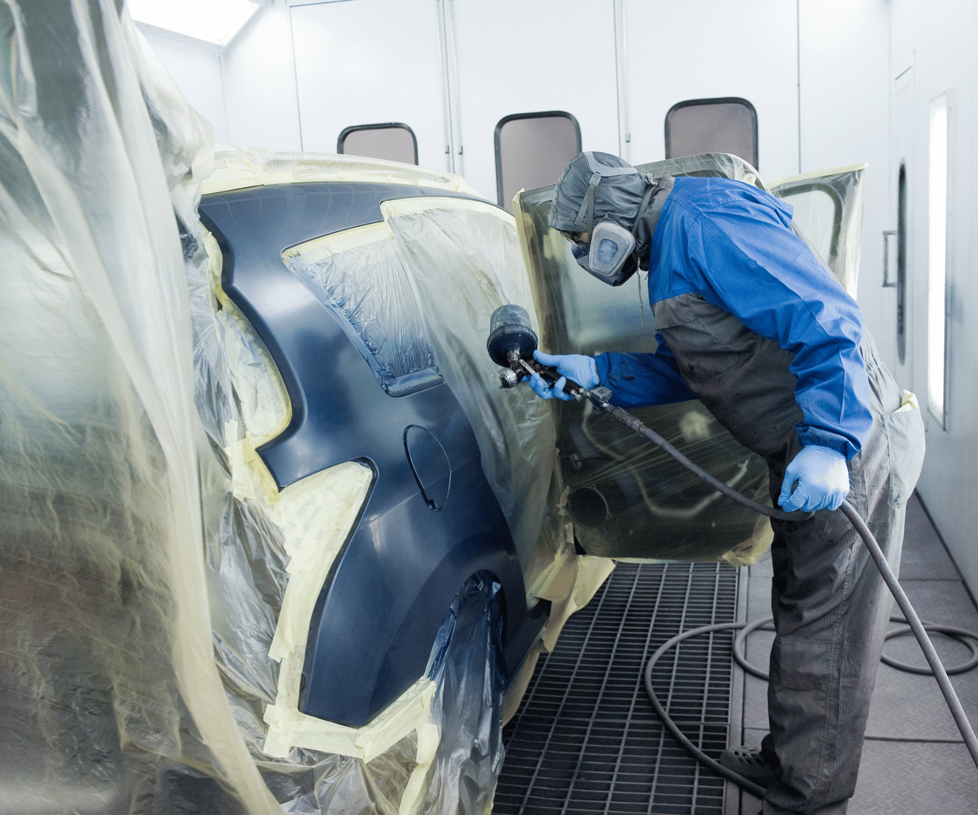 Na tym zdjęciu możemy zobaczyć lakiernika w specjalnym kombinezonie, który wykonuje proces malowania proszkowego samochodu. Równie profesjonalne usługi lakiernicze Dzierżoniów oferuje serwis Kasprowicz Auto.